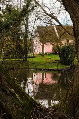 a reflection of a building in a body of water at Toad Hall in Swilland