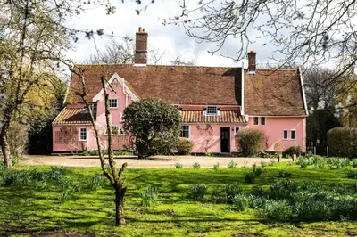 a pink house in the middle of a field at Toad Hall in Swilland