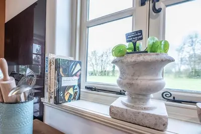 a vase sitting on a window sill with a plant at 3 Old School Cottages, Wissett in Halesworth