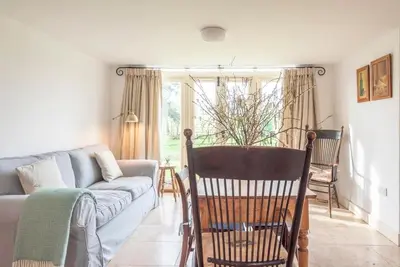 a living room with a couch and a chair at 3 Old School Cottages, Wissett in Halesworth