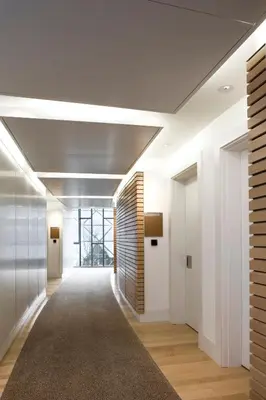 an office corridor with white walls and a carpet at Stephen Hawking Building Gonville and Caius College in Cambridge