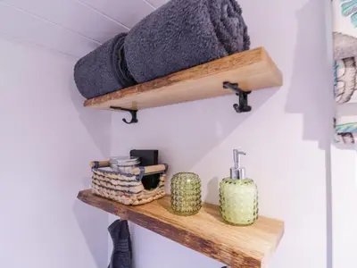 a bathroom with a wooden shelf with a mattress at Bumble's Retreat in Whepstead