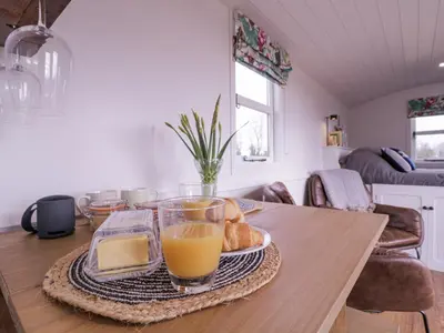 a table with a tray of bread and orange juice at Bumble's Retreat in Whepstead
