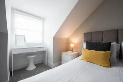 a bedroom with a bed with a yellow pillow and a window at Cosy, Bright, 1 Bed Flat in Brentwood