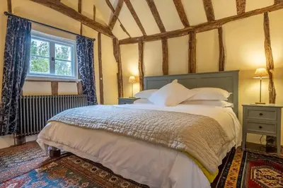 a bedroom with a bed and a window at Medieval cottage in rural village - Duke's Lodge in Bildeston