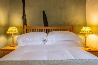 a bedroom with a bed with two lamps on tables at Medieval cottage in rural village - Duke's Lodge in Bildeston