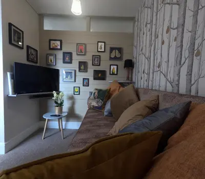 a living room with a couch and a flat screen tv at St Elmo Felixstowe in Felixstowe