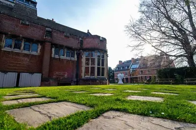 an old brick building with green grass in front of it at Westminster College in Cambridge