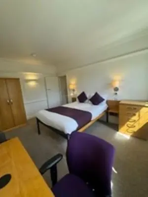 a hotel room with a bed and a table and chairs at Westminster College in Cambridge