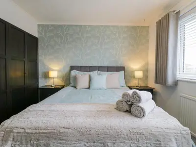 a bedroom with a large bed with towels on it at Hide and Sleep in Walton-on-the-Naze