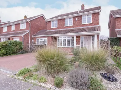 a brick house with white windows and grass at Hide and Sleep in Walton-on-the-Naze