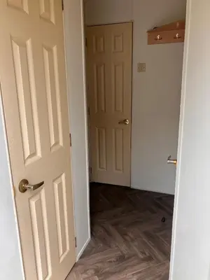 an empty room with an open door and wooden floors at Lazeeedays on Mersea Island in Colchester