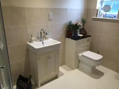 a bathroom with a white sink and a toilet at Relaxing country cottage bungalow in Yaxley