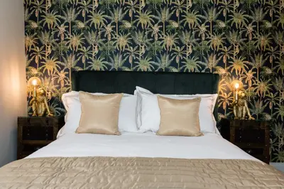 a bedroom with a bed with a floral wallpaper at Fun house in the heart of Colchester in Colchester