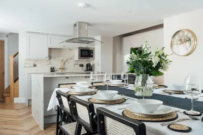 a dining room with a table with chairs and a kitchen at Fun house in the heart of Colchester in Colchester
