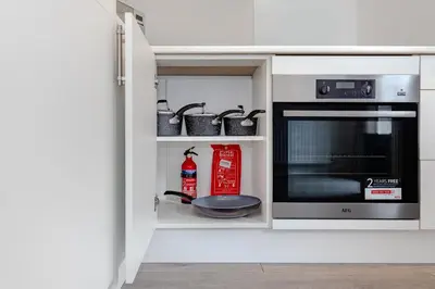 a kitchen with a microwave oven and pots and pans at Lovely 2 Bedroom House in Cheshunt