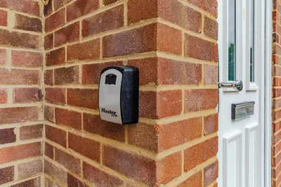 a mailbox on a brick wall next to a door at Lovely 2 Bedroom House in Cheshunt