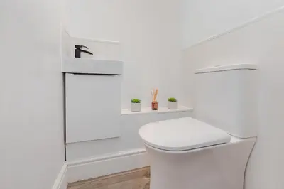 a white bathroom with a toilet and a shower at Lovely 2 Bedroom House in Cheshunt