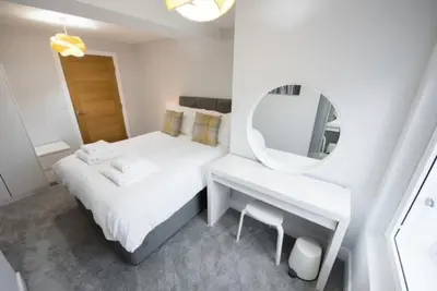 a white bedroom with a bed and a mirror at Modern,central 1 bedroom flat in Brentwood