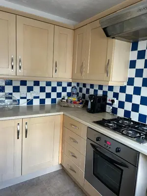 a kitchen with a stove and blue and white tiles at Stylish house centrally located in Bury Saint Edmunds