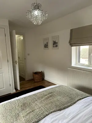 a bedroom with a bed and a chandelier at Stylish house centrally located in Bury Saint Edmunds