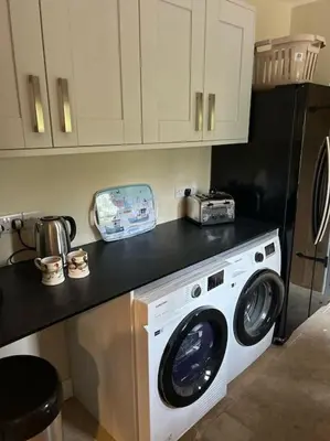 a kitchen with a washing machine in a kitchen at A family and dog friendly haven, The Hayloft. in Saxmundham