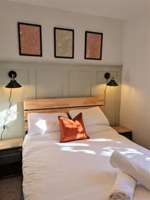 a bedroom with a white bed with two orange pillows at Bellropes Countryside Retreat in Bradwell on Sea