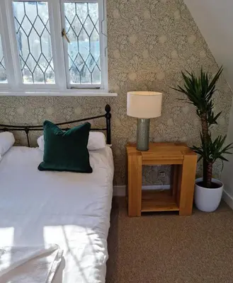 a bedroom with a bed and a table with a lamp at Bellropes Countryside Retreat in Bradwell on Sea
