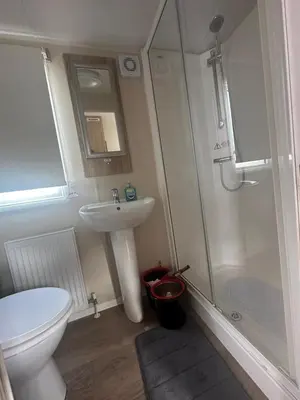 a bathroom with a toilet and a sink and a shower at 4 Bed 10 Berth Caravan Seawick Holiday Park in Saint Osyth