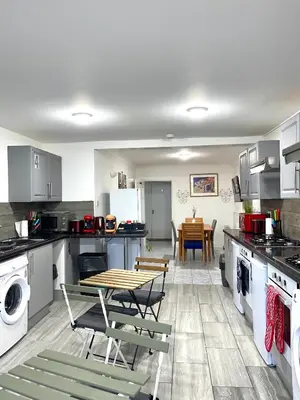 a kitchen with a table and chairs in it at Penn Gardens king size on suite room- 3 in Friern Barnet