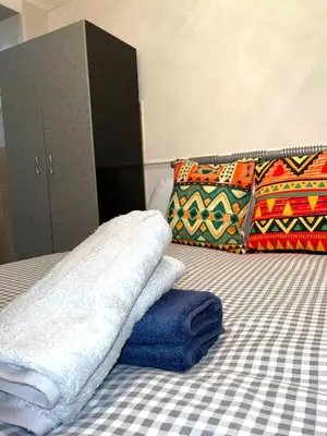 a bedroom with a bed with towels on it at Penn Gardens king size on suite room- 3 in Friern Barnet