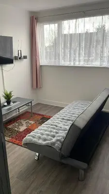 a bedroom with a bed in front of a window at 12 Penn Gardens- Apart 2 in Friern Barnet