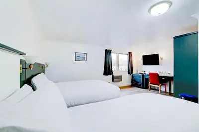 a hotel room with two beds and a desk at The Rivenhall Hotel in Witham, Chelmsford in Witham