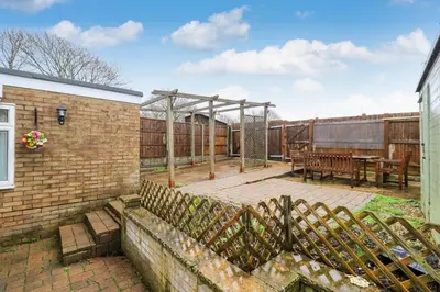 a backyard with a wooden fence and a picnic table at Tiger House Stevenage 5 Bed 4 Bath Group Bookings in Stevenage