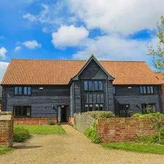 a large wooden house with a red roof at 3 Hazlewood in Aldringham