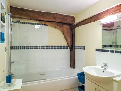 a bathroom with a bath tub and a sink at 3 Hazlewood in Aldringham