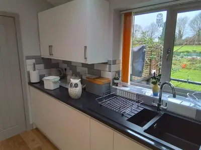 a kitchen counter with a sink and a window at Owlhoot Annexe in Sudbury