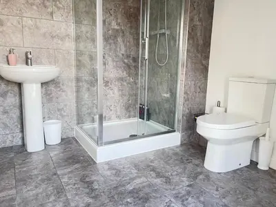 a bathroom with a shower and a toilet and a sink at Stylish Cambridge Apartment with Garden in Cambridge