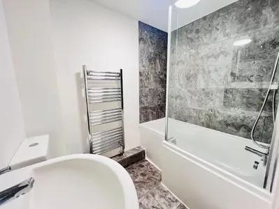 a white bathroom with a toilet and a shower at Stylish Cambridge Apartment with Garden in Cambridge