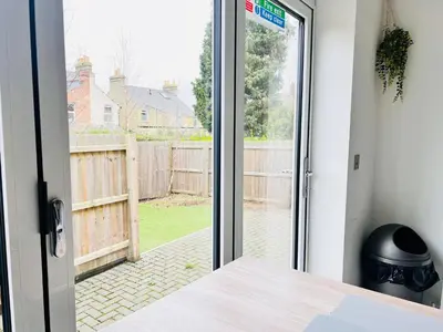 an open door with a view of a yard at Stylish Cambridge Apartment with Garden in Cambridge