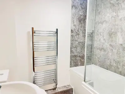 a bathroom with a sink and a toilet and a shower at Stylish Cambridge Apartment with Garden in Cambridge