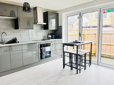 a kitchen with stainless steel appliances and a counter at Stylish Cambridge Apartment with Garden in Cambridge