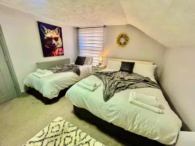 a bedroom with two beds and a picture of a cat at 6 Bedroom House - DISC0UNTS - Parking, Contractors, Group, Family in Ipswich
