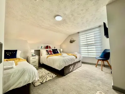 a bedroom with two beds and a window at 6 Bedroom House - DISC0UNTS - Parking, Contractors, Group, Family in Ipswich