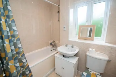 a bathroom with a sink and a toilet and a window at Group Retreat Perfect Home with FREE Parking in Freston