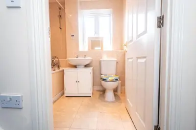 a bathroom with a toilet and a sink and a window at Group Retreat Perfect Home with FREE Parking in Freston
