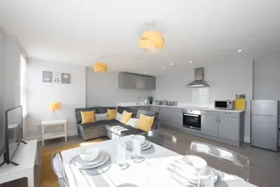 a living room with a couch and a table in a kitchen at Beautiful, Spacious 1 bed flat in Brentwood