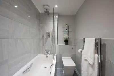 a bathroom with a tub and a toilet and a sink at Beautiful, Spacious 1 bed flat in Brentwood