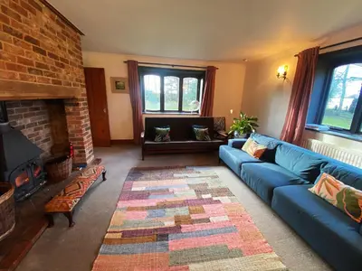 a living room with a blue couch and a fireplace at Rivendell in Diss