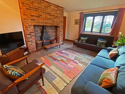 a living room with a blue couch and a fireplace at Rivendell in Diss